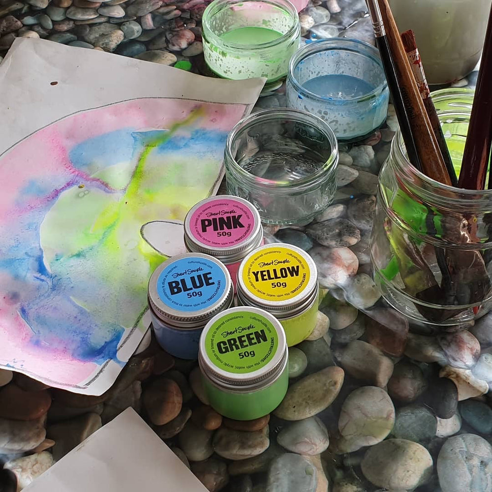 Colourist tins and jars on a painted desk