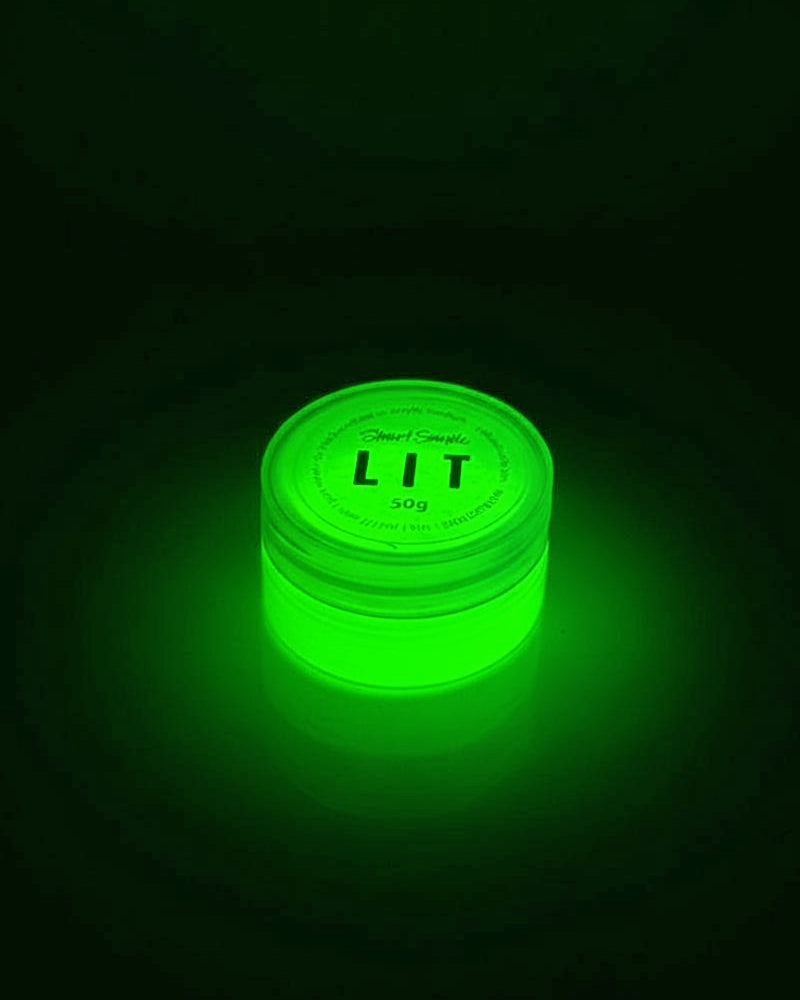 LIT glow pigment powder in a round, translucent green container, emitting a bright green glow against a dark background.