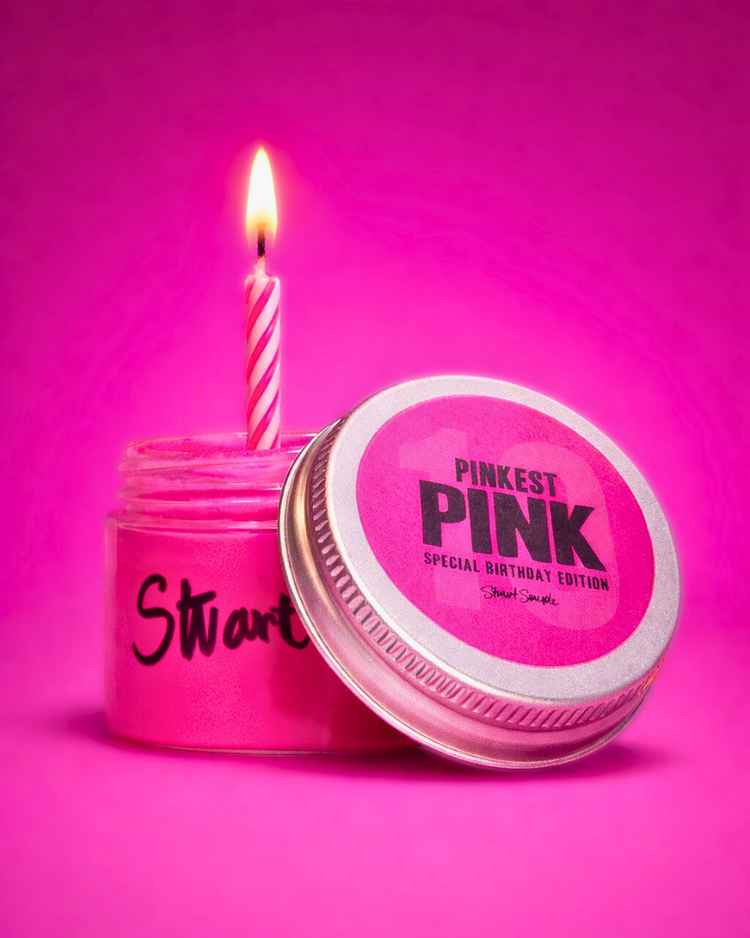 Pink powder in a silver tin with a pink birthday candle, set against a bright pink background.