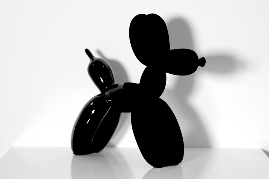 Two balloon dogs side by side, one gloss black, one painted in Black 4.0 that reads as a cut-out