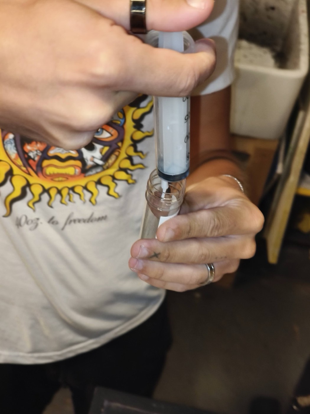 A syringe filling a small glass vial
